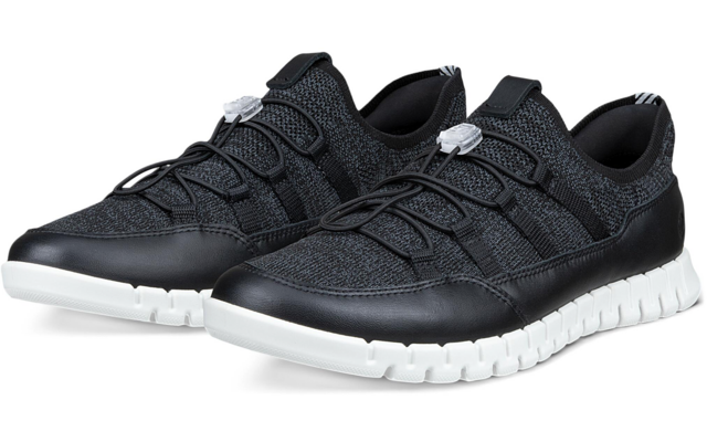 Par de zapatillas negras con parte superior de punto, cordones elásticos con tope y suelas blancas, colocadas inclinadas una junto a la otra sobre fondo blanco