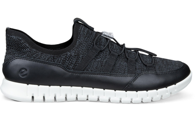 Zapatilla negra con empeine de punto, cordones elásticos y suela blanca, vista lateral