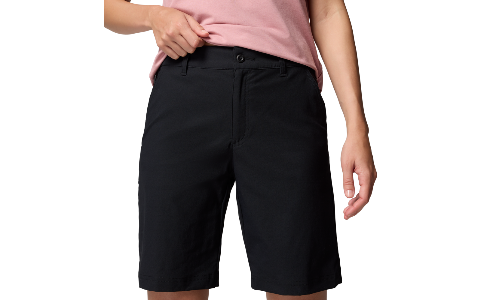 Persona con pantalones cortos negros y camiseta rosa, solo parte inferior visible