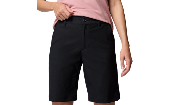 Persona con pantalones cortos negros y camiseta rosa, solo parte inferior visible