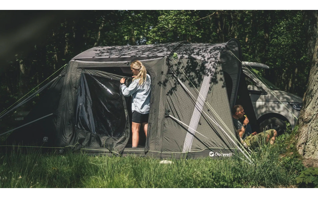 Kind steht vor einem großen Zelt im Wald