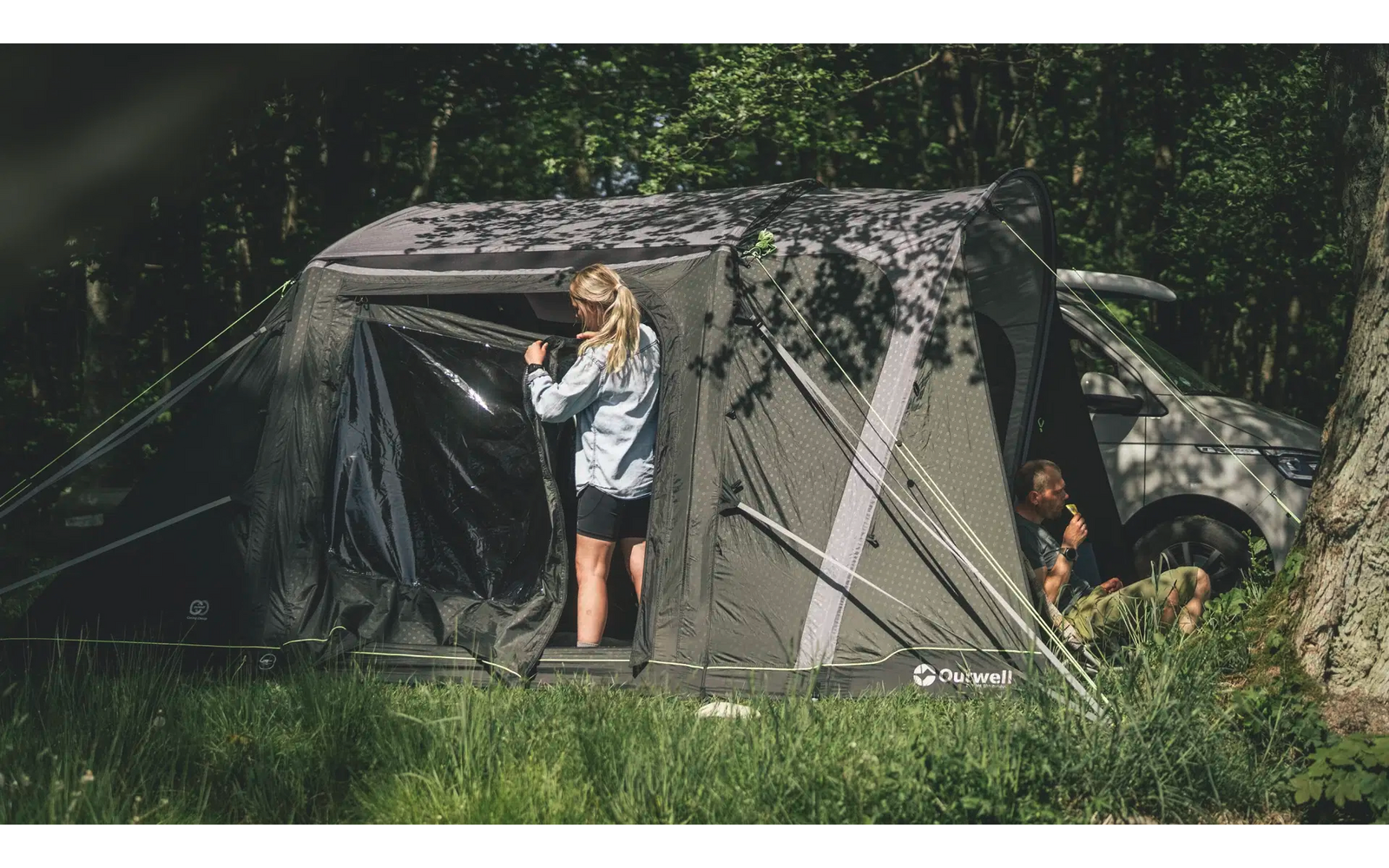Kind steht vor einem großen Zelt im Wald