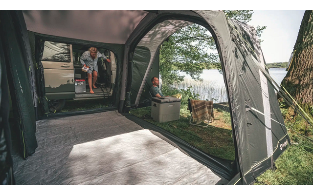 Innenansicht eines Zeltes mit offenem Eingang und Blick auf einen Garten mit Bäumen