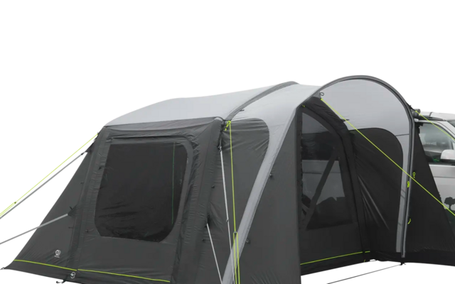 Ein Wohnmobil mit einem angeschlossenen grauen Vorzelt auf einer hellen Fläche