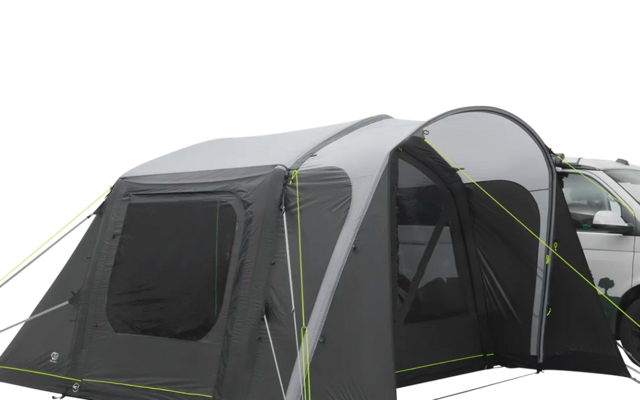 Een camper met een aangehekte grijze luifel op een lichte ondergrond