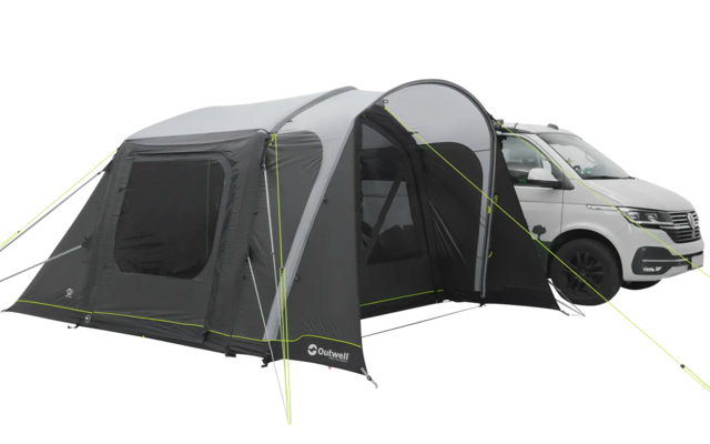 Ein Wohnmobil mit einem angeschlossenen grauen Vorzelt auf einer hellen Fläche
