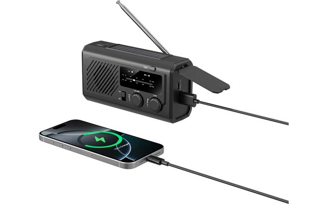 Schwarzes tragbares Radio mit ausgezogener Antenne, zwei angeschlossenen Kabeln und Smartphone mit grünem Batteriesymbol auf dem Display
