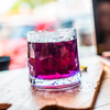 Glas mit rotem Getränk auf Holztisch