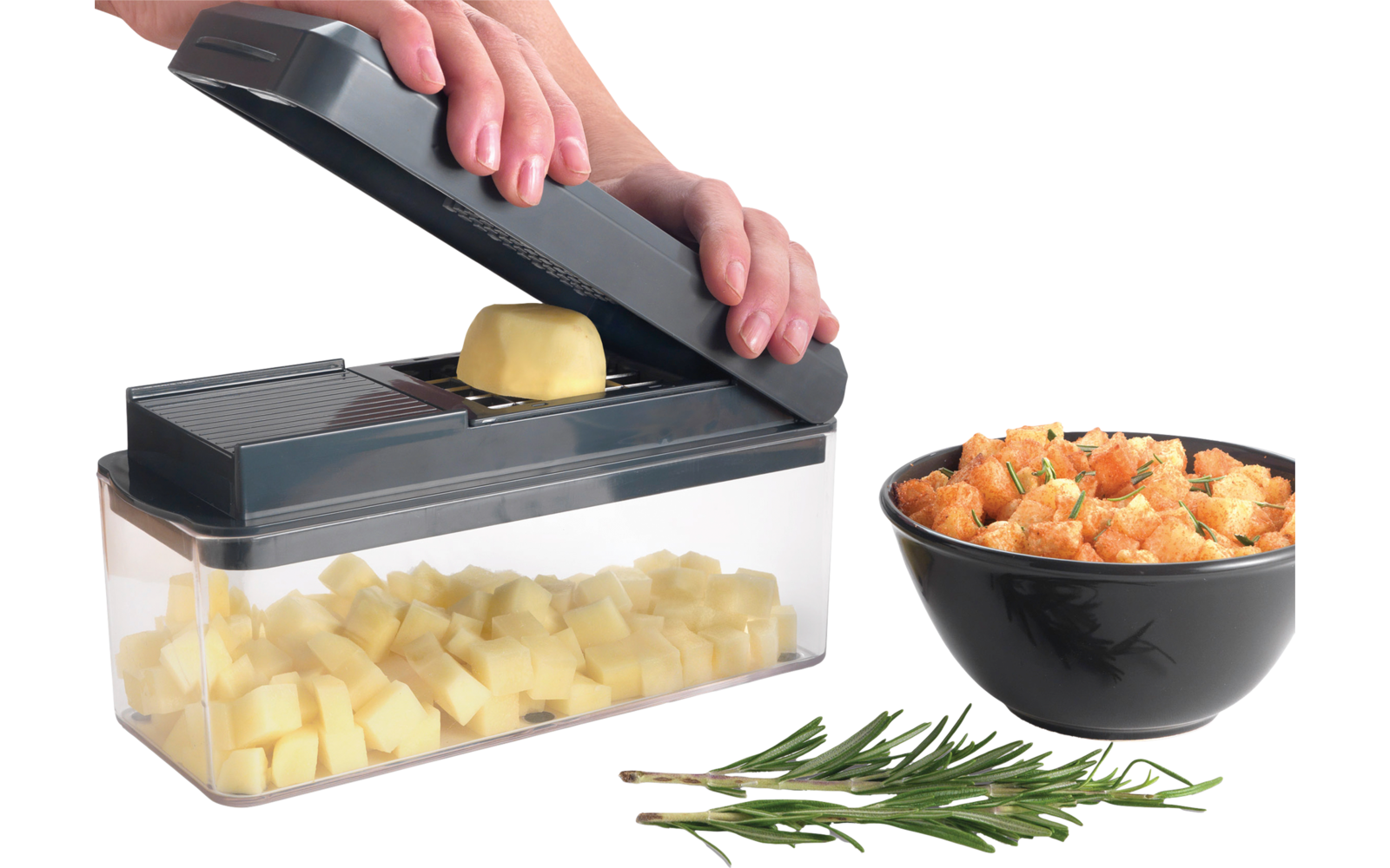 Handen persen een teentje knoflook met een knoflookpers boven een kom met gehakte knoflook. Naast de kom staat een zwart bord met geplette knoflook en wat kruiden