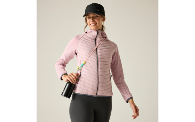 Person mit schwarzer Baseballkappe, rosa gesteppter Jacke, schwarzen Leggings, hält schwarze Trinkflasche an Schulterband, heller einfarbiger Hintergrund