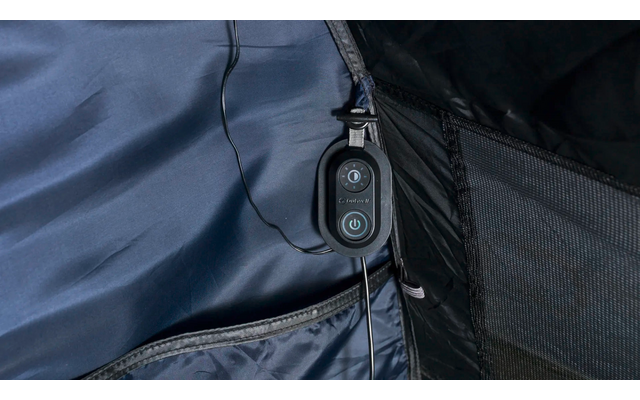 Nahaufnahme der Innenseite einer Jacke mit einem schwarzen, ovalen Bedienelement mit zwei Tasten und einem Power-Symbol, daran befestigte Kabel, Reißverschluss und Netzinnenfach