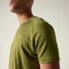 Buste d'une personne portant un t-shirt vert olive, menton et cou partiellement visibles