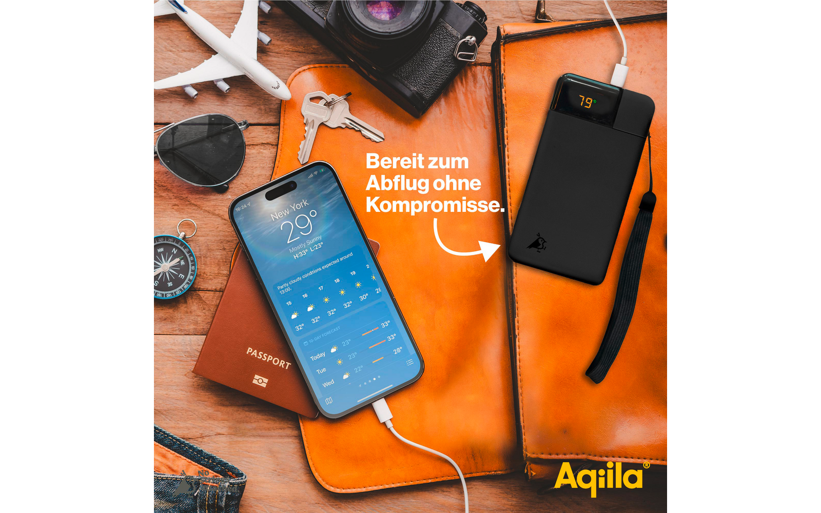 Smartphone avec écran bleu sur tissu orange, à côté d'un appareil photo, une figurine d'avion et des lunettes de soleil