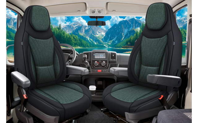 Innenraum eines Fahrzeugs: zwei grüne Vordersitze mit Armlehnen, Lenkrad und Armaturenbrett; große Windschutzscheibe mit Bergen und See