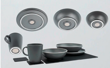 Grijs servies met kopjes, kommen, borden en onderzetters op witte achtergrond