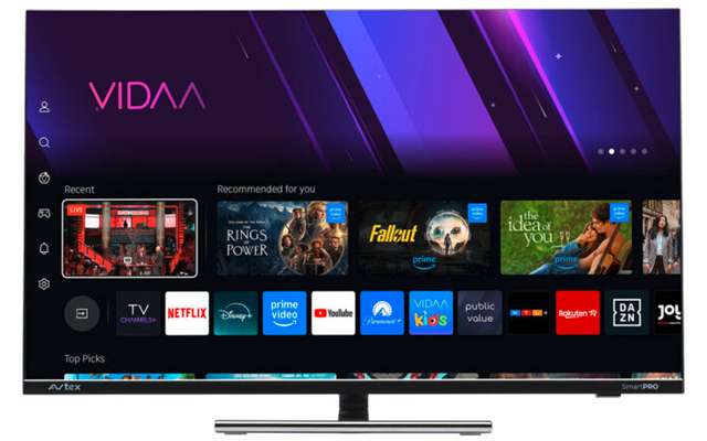 Flacher Fernseher auf Standfuß, Bildschirm mit lila Verlaufshintergrund und Schriftzug 'VIDAA', darunter Reihen von App-Symbolen (z. B. Netflix, Prime Video, YouTube) und kleinen Vorschaubildern