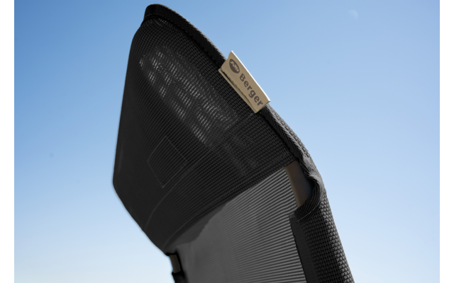 Close-up van een zwarte mesh stoelrugleuning met een beige label met "berger" tegen een blauwe lucht
