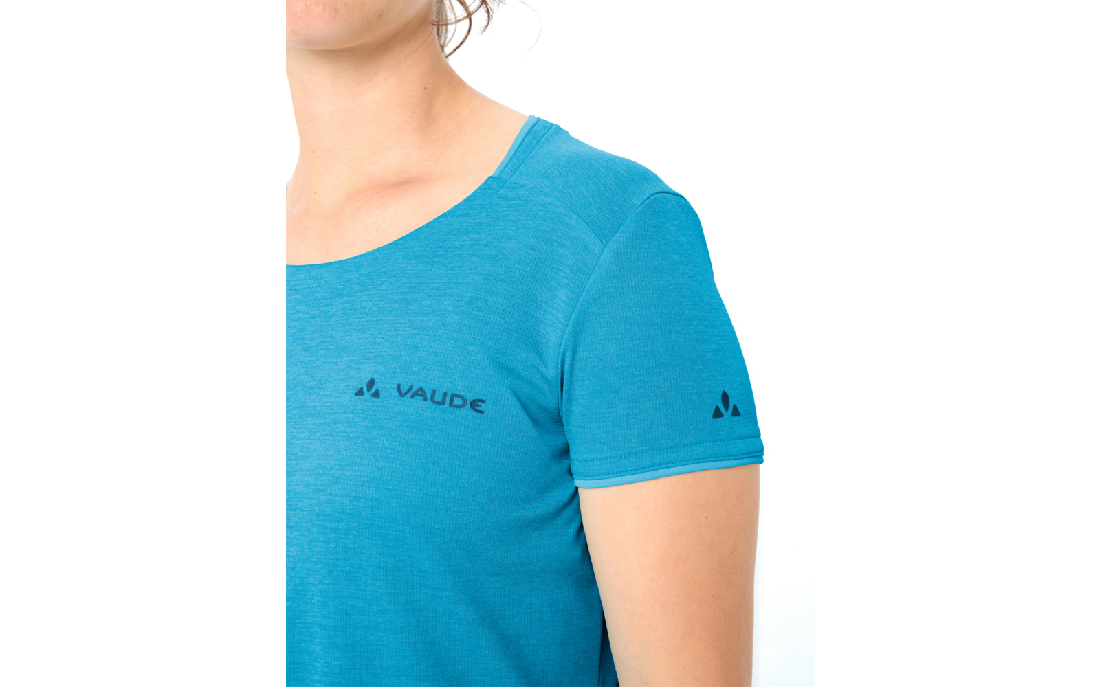 Oberkörper einer Person, Hals und Kinn sichtbar, trägt ein türkisfarbenes kurzärmeliges T‑Shirt mit der Aufschrift "VAUDE" auf der Brust und kleinem dreieckigen Logo auf dem Ärmel