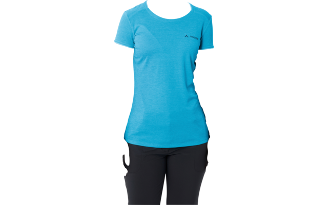 Donna in piedi di fronte alla fotocamera su sfondo bianco, indossa una maglietta blu a maniche corte e pantaloni neri, mani lungo i fianchi