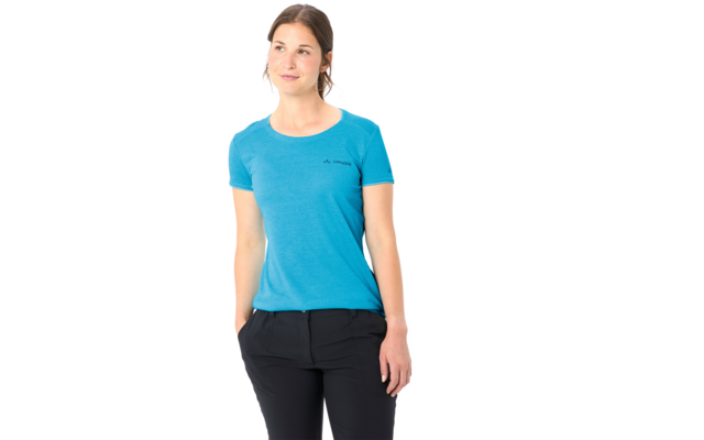 Person mit blauem T-Shirt und schwarzer Hose, Hände in den Taschen, schaut nach links, weißer Hintergrund