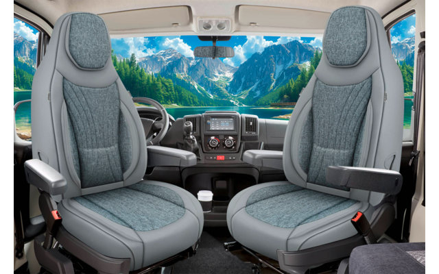 Zwei graue Vordersitze mit Armlehnen, Armaturenbrett mit Lenkrad und Mittelkonsole, große Windschutzscheibe mit Bergen und See im Hintergrund