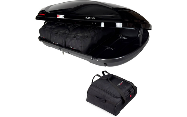 Geöffnete schwarze Dachbox mit zwei schwarzen Reisetaschen im Inneren und einer einzelnen schwarzen Reisetasche davor