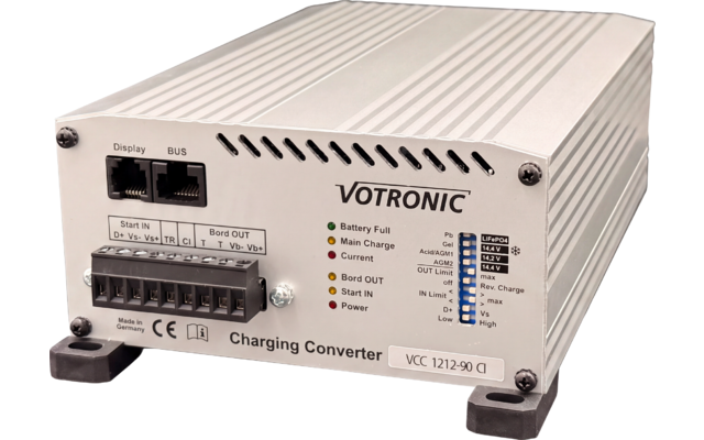 Boîtier métallique rectangulaire argenté avec inscriptions 'VOTRONIC' et 'Charging Converter', voyants LED, deux ports RJ45 ('Display', 'BUS'), borne à vis noire, numéro de modèle 'VCC 1212-90 CI', quatre pieds en caoutchouc noirs