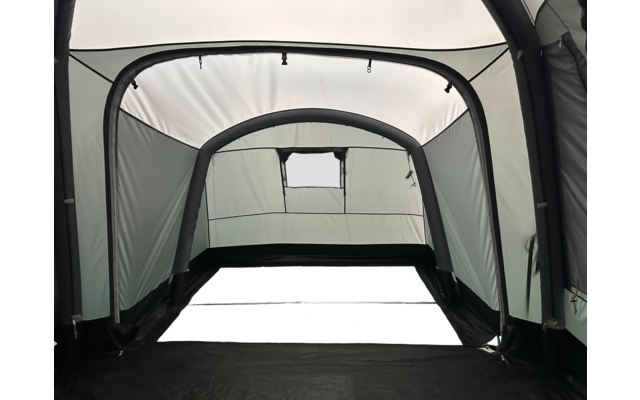 Innenraum eines hellgrauen Zelts mit gebogenen Stangen, rechteckigem Fenster an der Stirnseite und schwarzem Boden