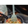 Pfanne mit geschnittenem buntem Gemüse (Karotten, Paprika, Zucchini), grüner geschlitzter Pfannenwender in der Pfanne, schwarzer Griff links sichtbar