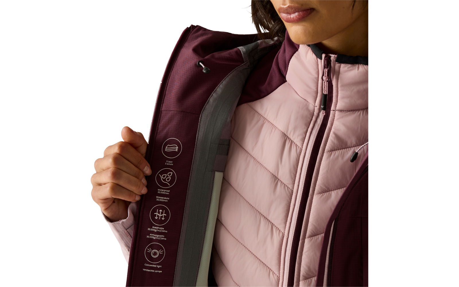 Nahaufnahme des Oberkörpers einer Person, die eine burgundrote Außenjacke aufhält; darunter eine hellrosa gesteppte Innenjacke mit Reißverschluss; weiße Piktogramme auf der Innenseite der Außenjacke; Hand hält die Klappe; Mund und Kinn sowie heller H