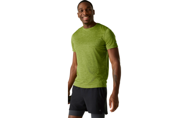 Lächelnde Person in grünem kurzärmeligem T-Shirt und schwarzen Sportshorts, steht und hält eine schwarze Trinkflasche vor hellem Hintergrund