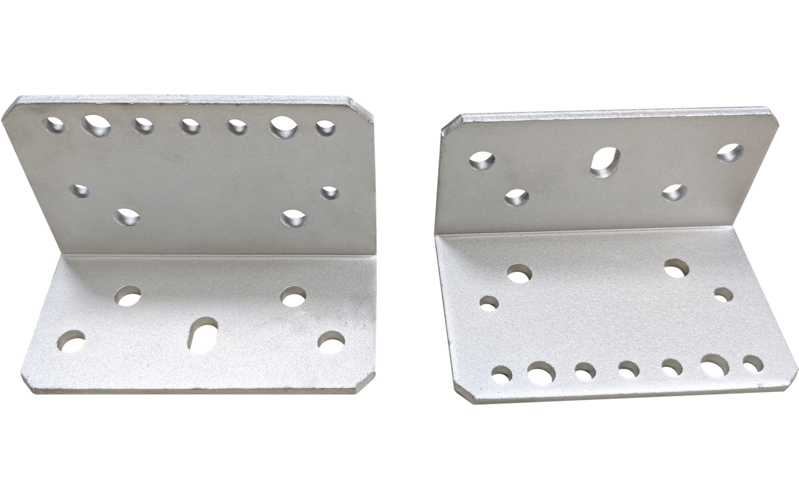 Zwei silberne L-förmige Metallwinkel nebeneinander auf weißem Hintergrund, mit runden und länglichen Schraubenlöchern