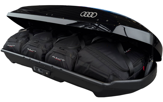 Geöffneter schwarzer Dachkoffer mit vier schwarzen Reisetaschen, Audi-Logo auf dem Deckel