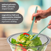 Deux mains tiennent des pinces à salade turquoise au-dessus d'un bol en verre contenant de la salade verte et des lanières de poivron rouge ; deux encadrés de texte en allemand et en anglais
