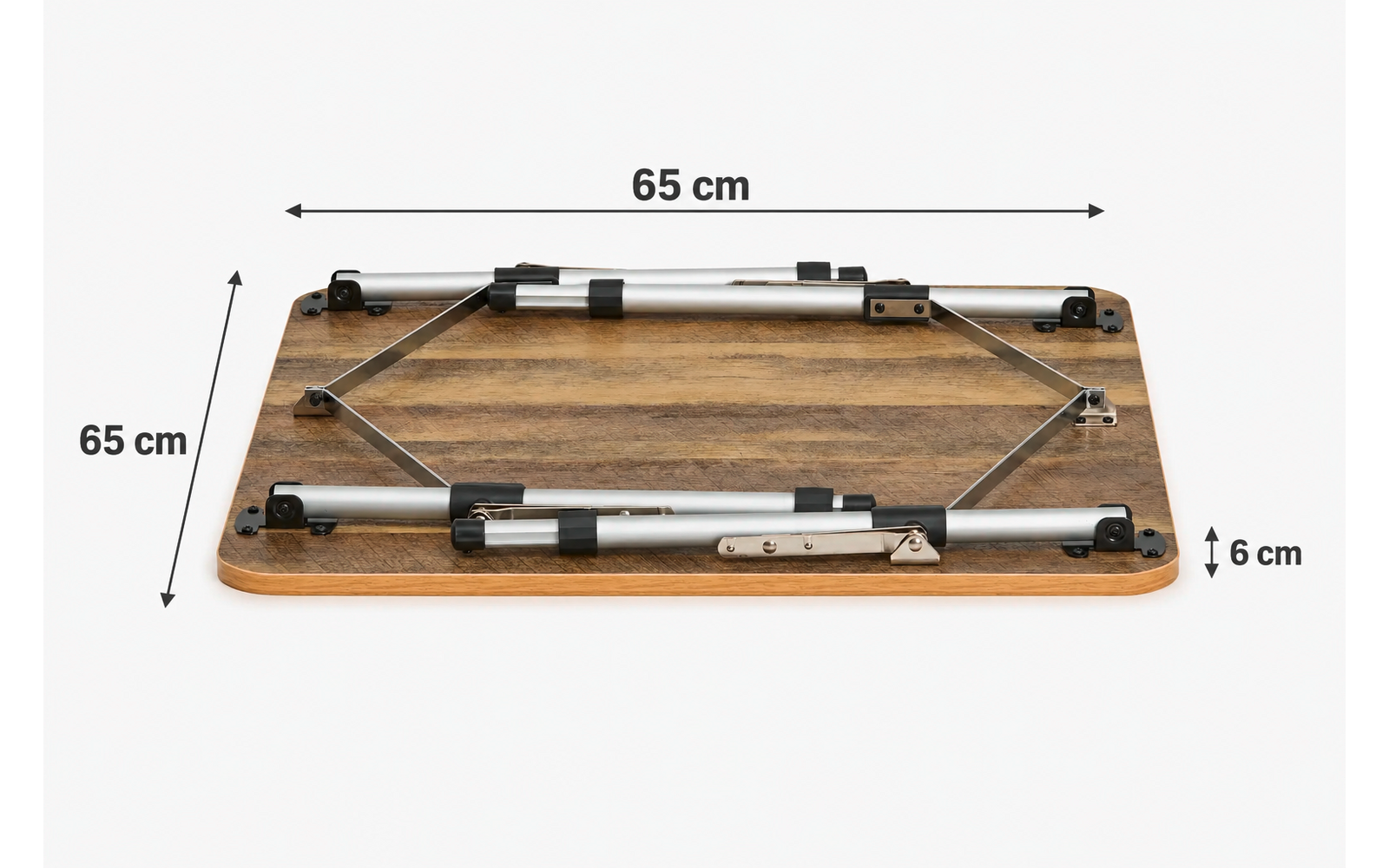Quadratische Holzplatte mit sichtbarer Holzmaserung, darauf befestigtes silbernes Metallgestell in X‑Form, vier schwarze Kunststoffhalterungen, Messpfeile mit Beschriftung '65 cm' oben und links sowie '6 cm' rechts, weißer Hintergrund
