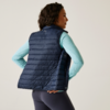 Vrouw van achteren met donkerblauw doorgestikt vest en lichtgekleurde trui