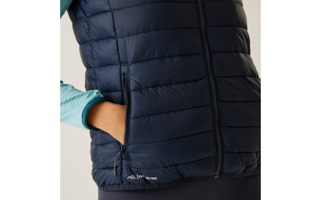 Persoon draagt een donkerblauwe gewatteerde bodywarmer, hand in de zak
