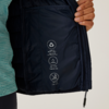 Hand houdt open zak van een donkerblauw kledingstuk met drie witte symbolen en teksten binnenin
