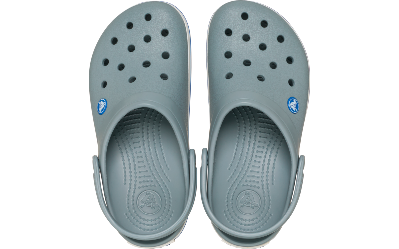 Paar lichtgrijze rubberen klompen van bovenaf, met meerdere ventilatiegaatjes, omgeklapte hielriemen en een rond logo aan de buitenkant