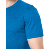 Bovenlichaam van een persoon met een blauw T-shirt met korte mouwen, zichtbaar van nek tot bovenarm, klein logo op de borst