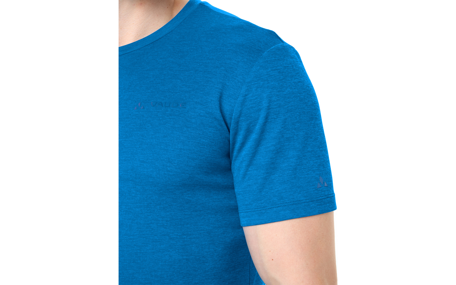Bovenlichaam van een persoon met een blauw T-shirt met korte mouwen, zichtbaar van nek tot bovenarm, klein logo op de borst