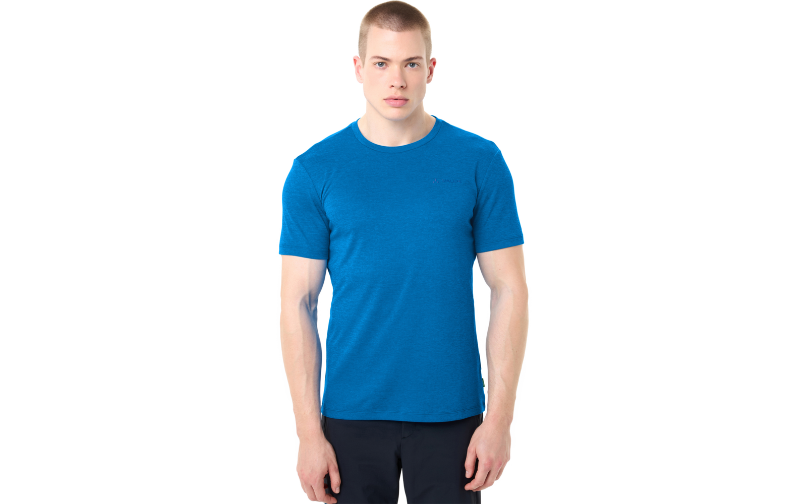 Man met kort lichtbruin haar en een blauw T-shirt, frontaal staand tegen een witte achtergrond, armen langs het lichaam