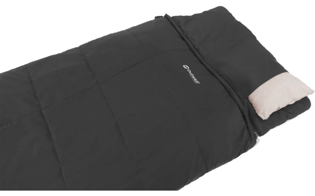 Zwart slaapzak met een licht kussen, liggend op een witte ondergrond