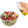 Glas-Schüssel mit gemischten Salatblättern, Radieschenscheiben, kleinen roten und gelben Tomaten sowie lila und rosa Blüten; eine Hand hält eine Glasflasche mit gelber Flüssigkeit über dem Salat