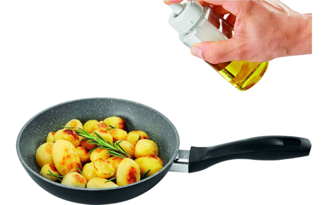 Hand hält ein kleines Glasfläschchen mit gelber Flüssigkeit über eine Pfanne mit goldbraunen kleinen Kartoffeln und einem Rosmarinzweig auf weißem Hintergrund