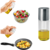 Hand sprüht Öl aus einer Sprühflasche über eine Schüssel mit Salat; weitere Hand sprüht Öl über eine Pfanne mit Kartoffeln; stehende Ölsprühflasche mit Metallverschluss