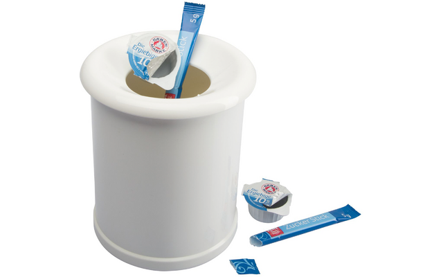 Weißes rundes Gefäß mit breitem Rand und zentraler Öffnung; darin und daneben drei blaue, längliche Verpackungen, davon eine teilweise geöffnet, und zwei kleine weiße Portionsbecher mit blauer Folienoberseite