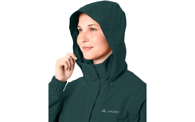 Person mit hochgezogener dunkelgrüner Kapuzenjacke, rechte Hand hält die Kante der Kapuze, Markenlogo "Vaude" auf der Brust sichtbar