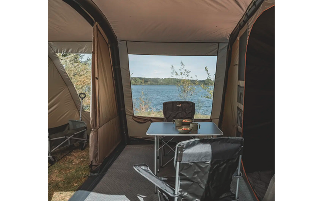 Blick aus einem Zelt auf einen See mit Bäumen im Hintergrund