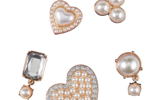 Cinq éléments en or rosé: deux formes en cœur avec petites perles et pierres claires; un groupe de trois perles rondes; une pierre claire rectangulaire facettée avec une petite perle pendante; une grande perle ronde avec une petite perle pendante